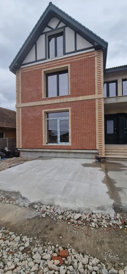 Casă din cărămidă roșie cu fronton din lemn