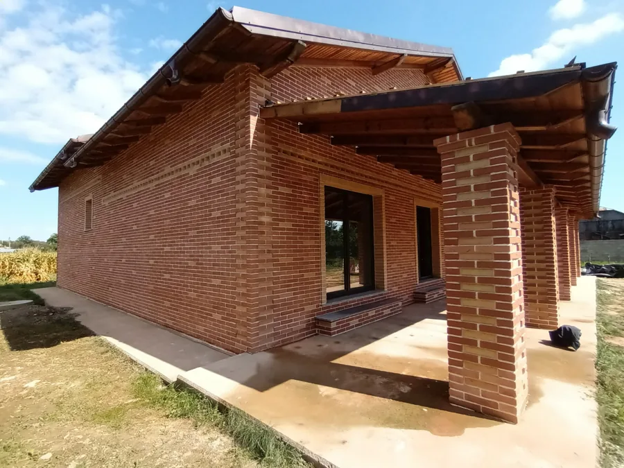Casă din cărămidă aparentă cu terasă pe coloane