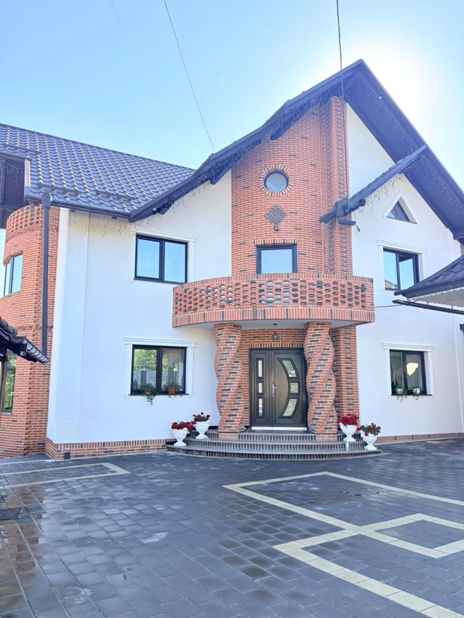 Casă finalizată cu balcon din cărămidă aparentă